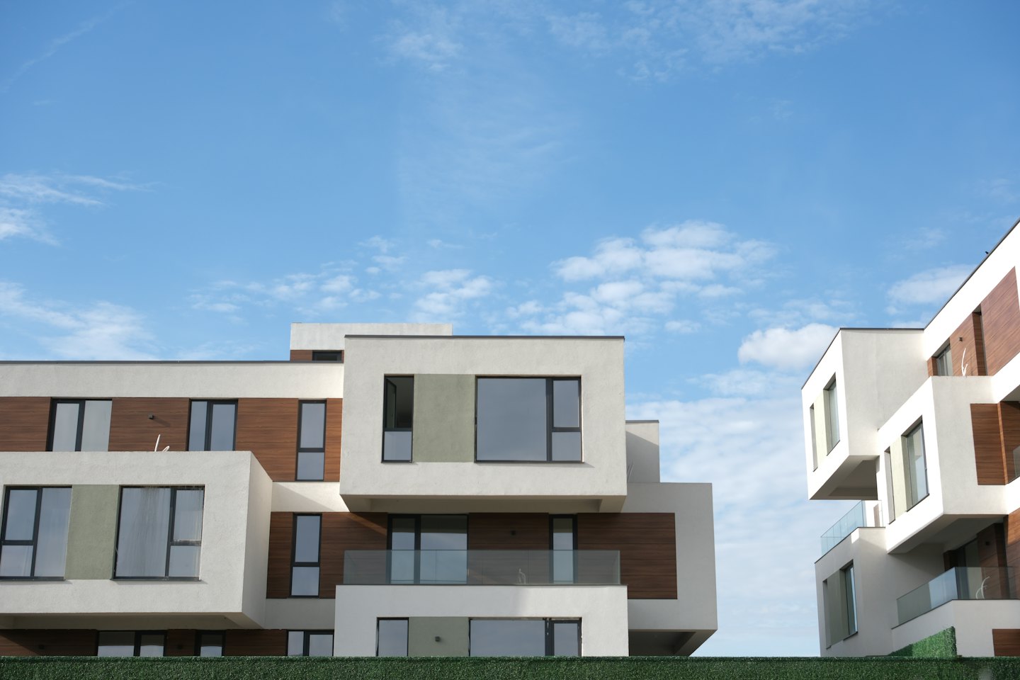 Moderne Wohnhäuser mit weißen Fassaden und Holzverkleidung.