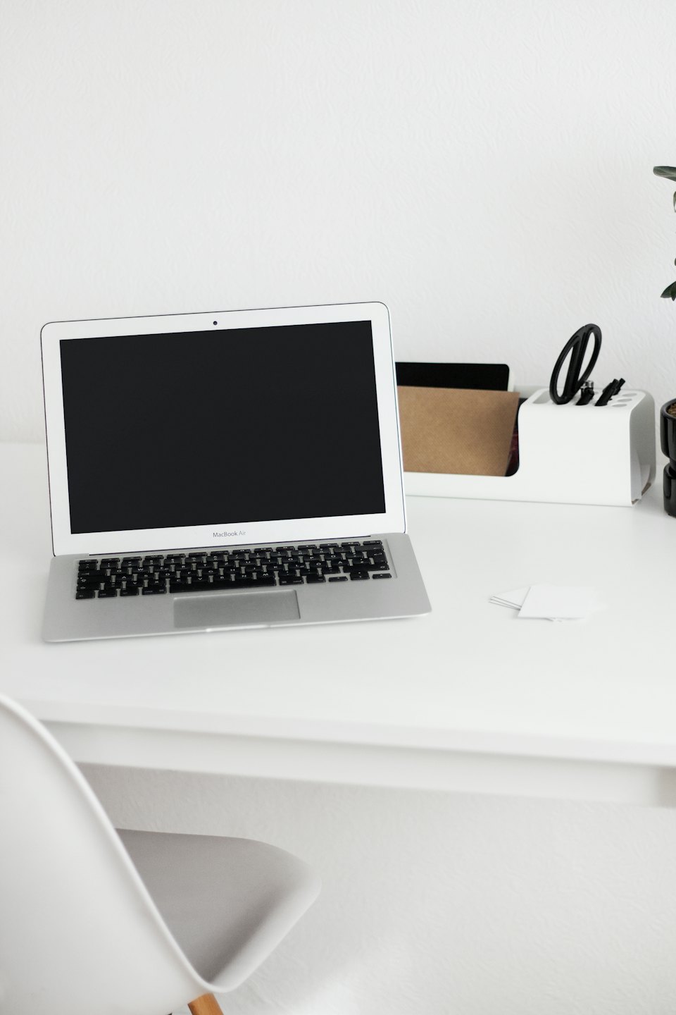 Laptop und Schreibtisch-Organizer auf einem weißen Schreibtisch.