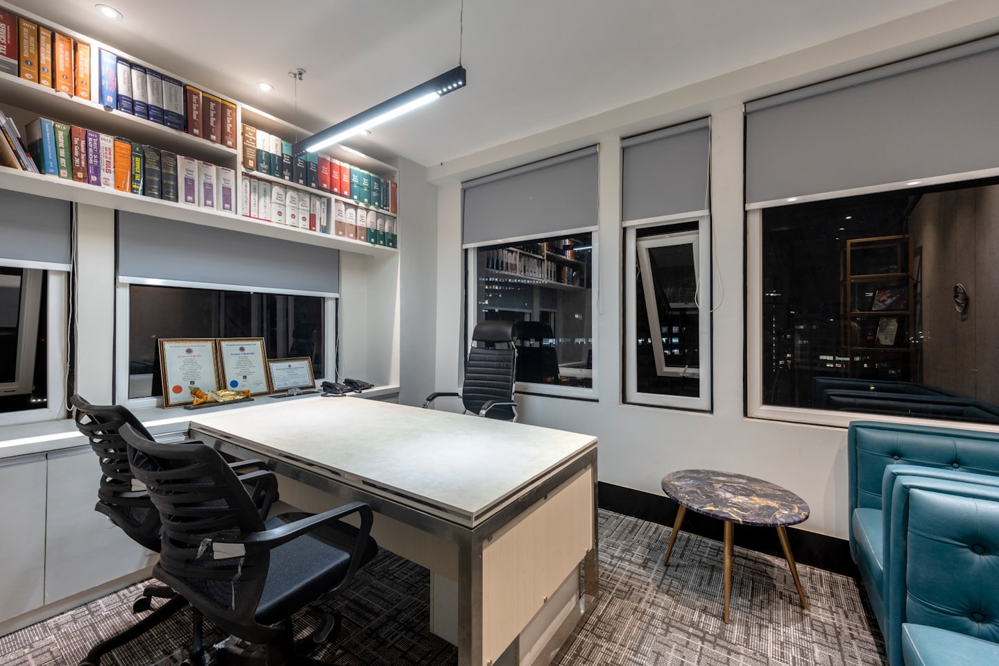 Modernes Büro mit Schreibtischstühlen und Bücherregalen in der Nähe von Fenstern.